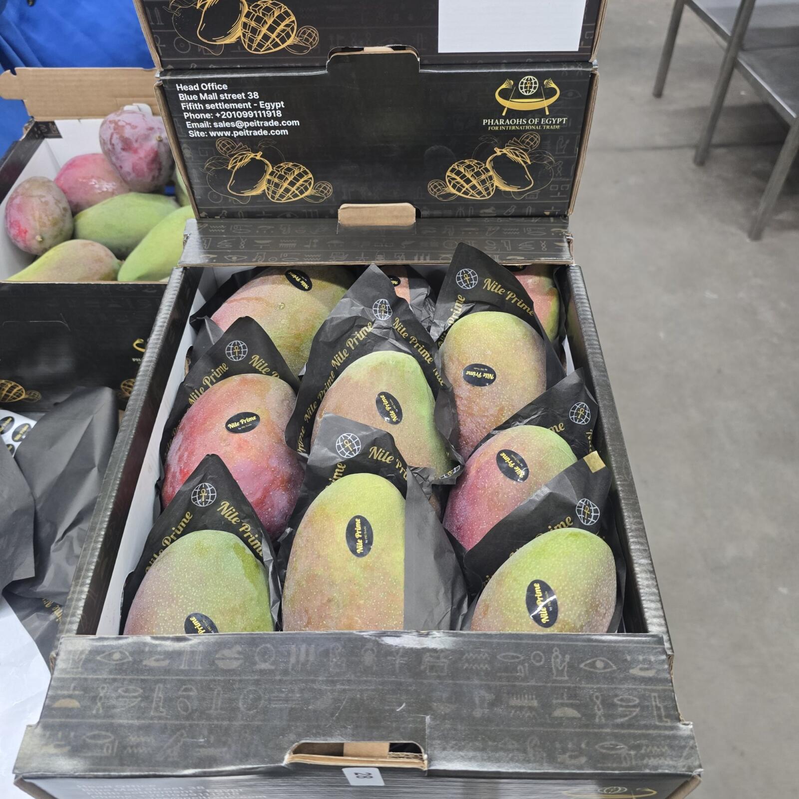 Open Nile Prime carton of red-blush Egyptian mangoes showing the printed brand panel